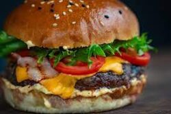 image of a hamburger with cheese, lettuce, onion and tomato