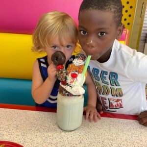 Two boys sharing a milkshake