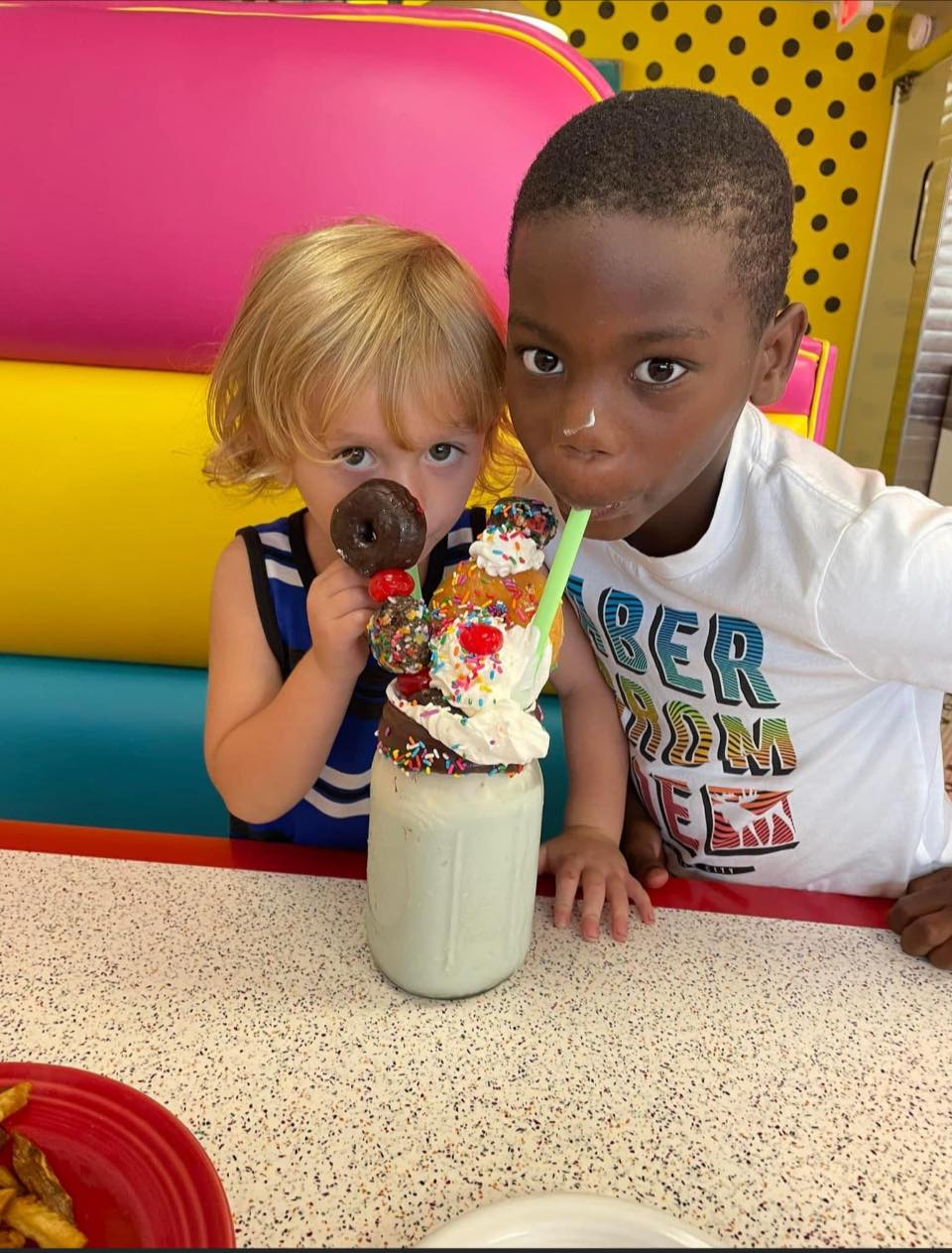 Two boys sharing a milkshake