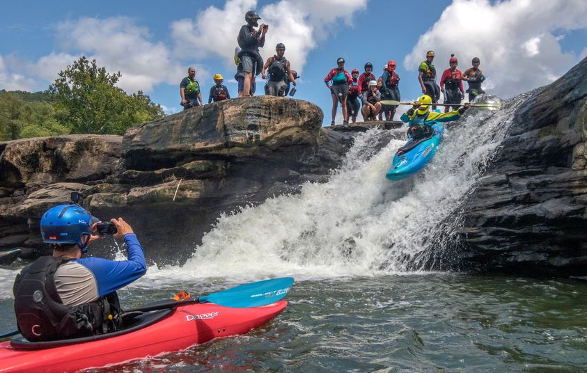 kayakers participating in a safety clinic at a waterfall
