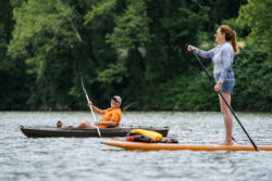 Man in kayak and woman on standup paddleboard on a river