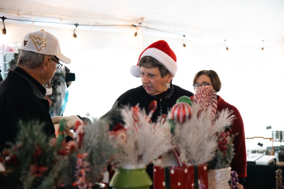 woman wearing a Santa hat shopping at an outdoor street fair