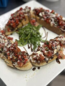 white plate with four pieces of bruschetta