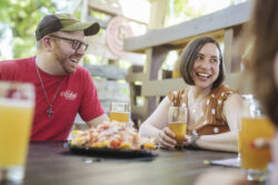 man and woman sharing a plate of nachos and beer