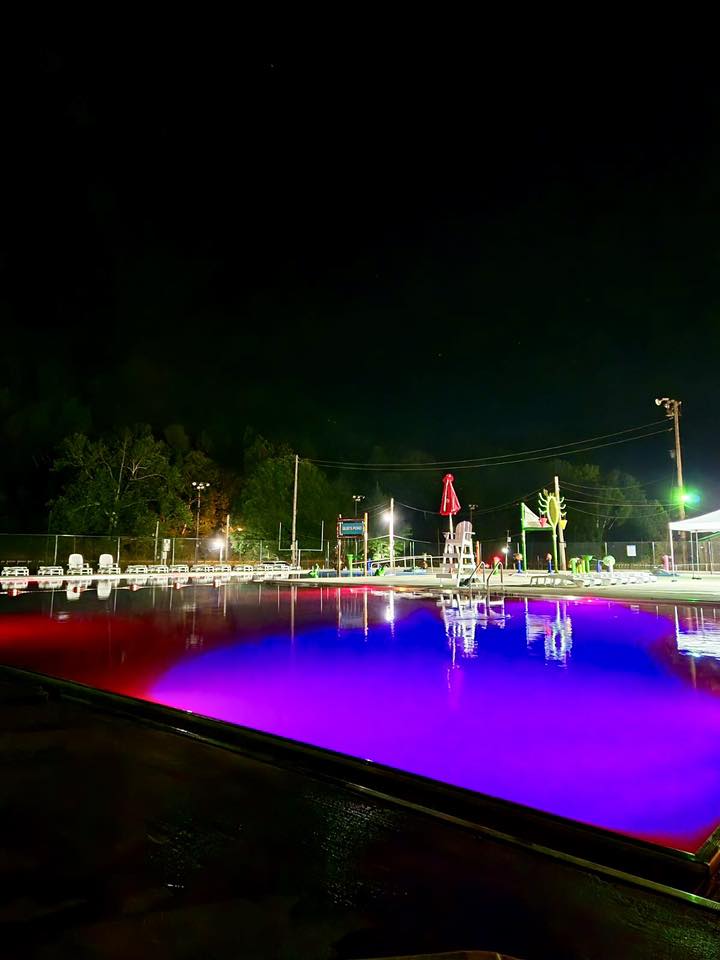 Photo of a pool with lights at night