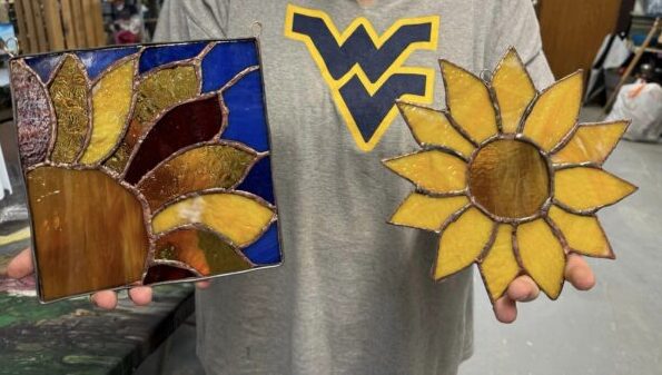 Photo of person holding stained glass art pieces